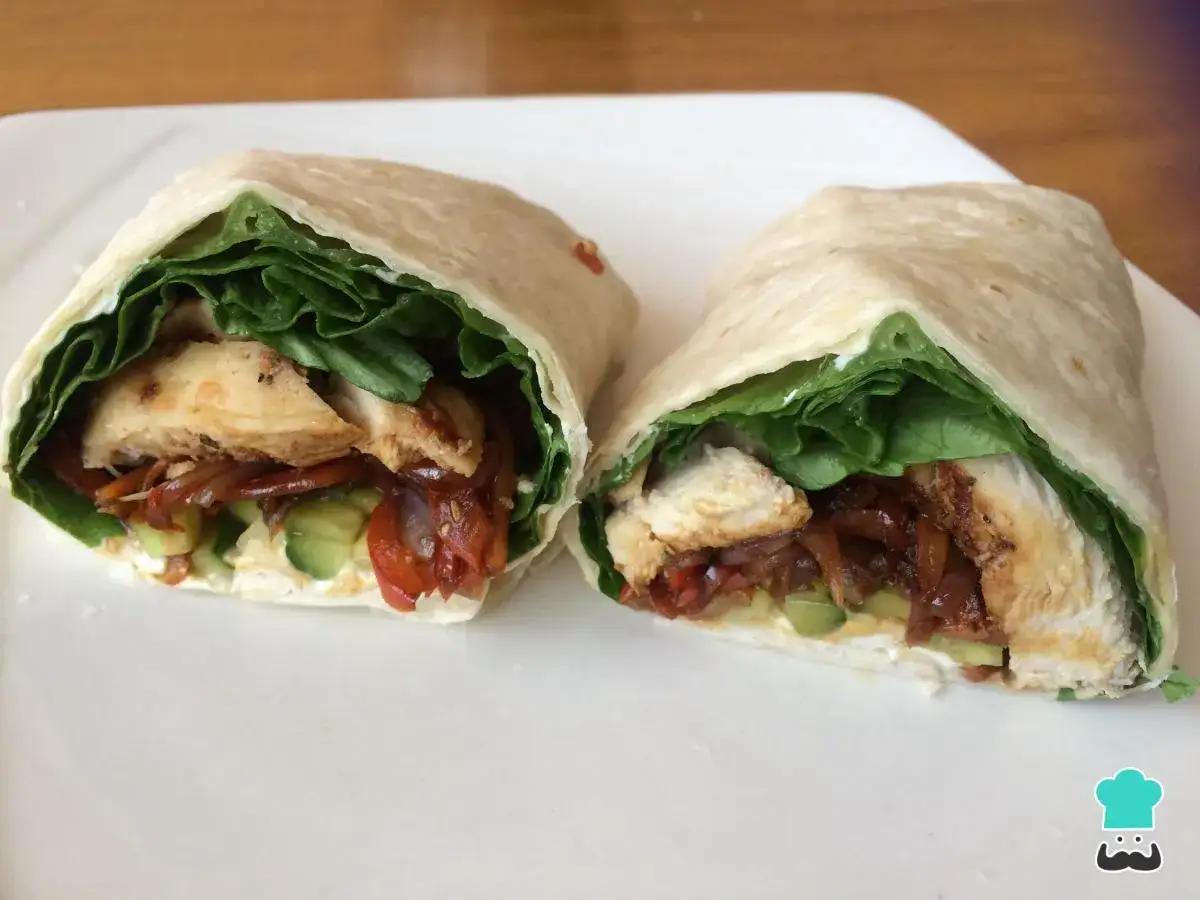 Delicioso wrap de pollo con lechuga fresca, pepino, tomate y cebolla caramelizada.