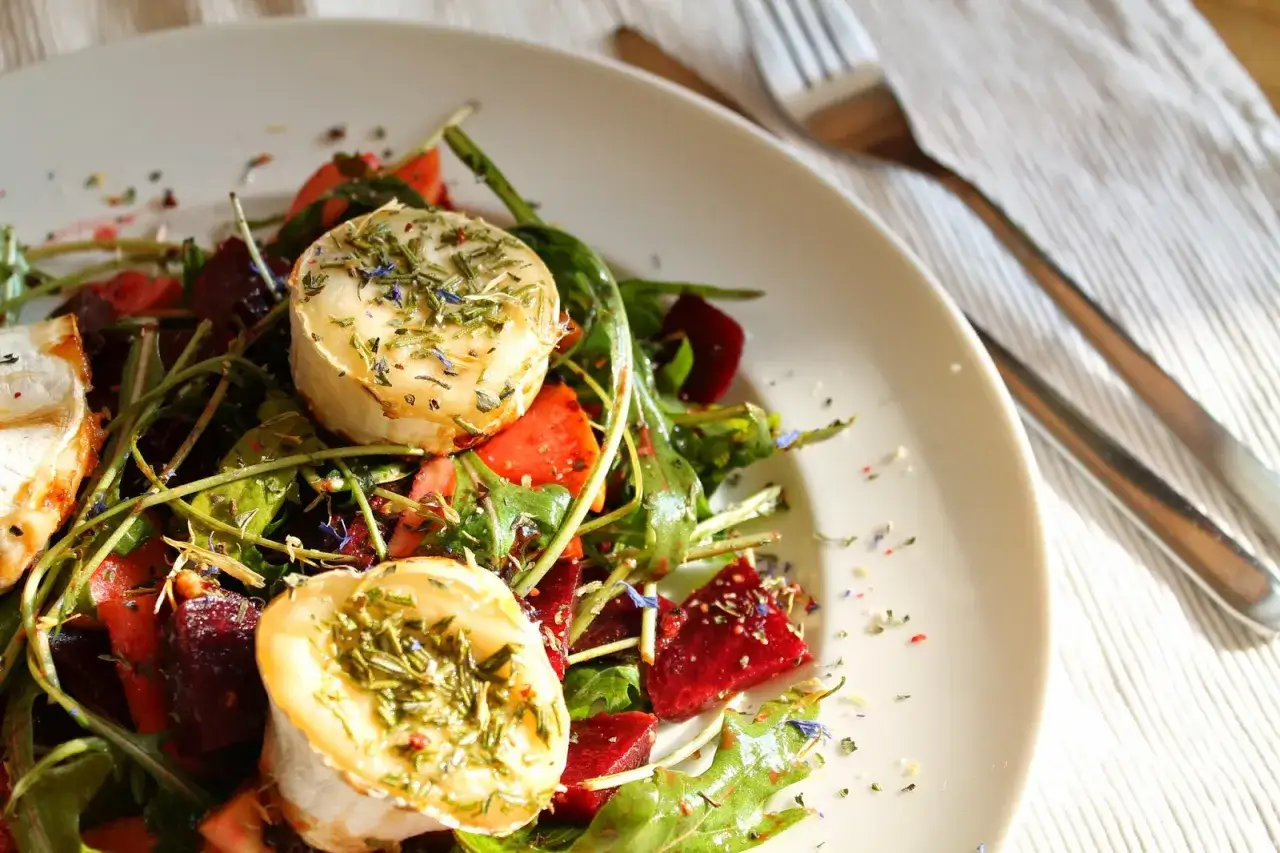 Ein köstlicher Rote Bete Salat mit Ziegenkäse, garniert mit Kräutern und Blüten.
