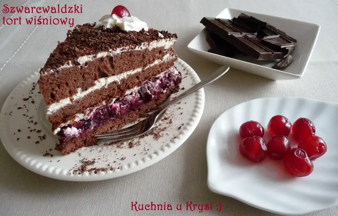 Pyszny tort szwarcwaldzki z wiśniami, bitą śmietaną i czekoladową posypką. Obok kawałki gorzkiej czekolady i kilka wiśni.