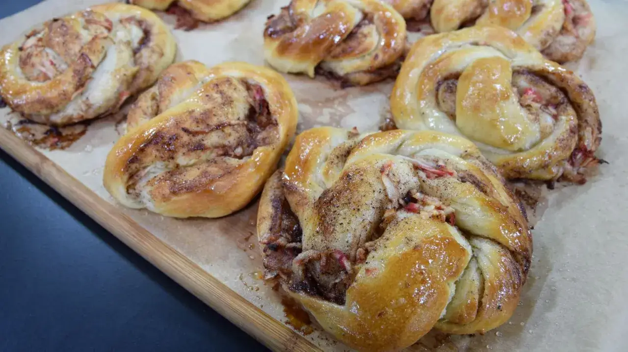 Nybakade kanelbullar med &auml;pple och kanel, redo att avnjutas. Doften sprider sig i k&ouml;ket.