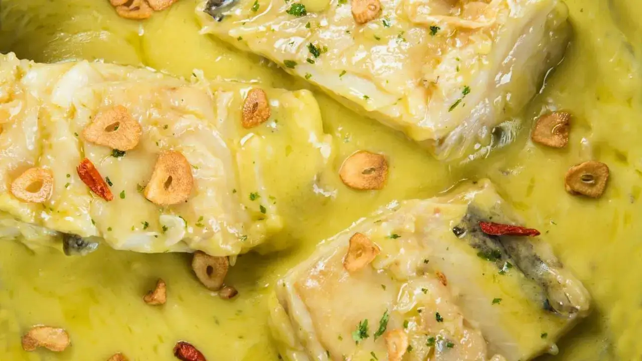 Bacalao al pil pil, con láminas de ajo crujiente y guindilla, bañado en su salsa emulsionada.