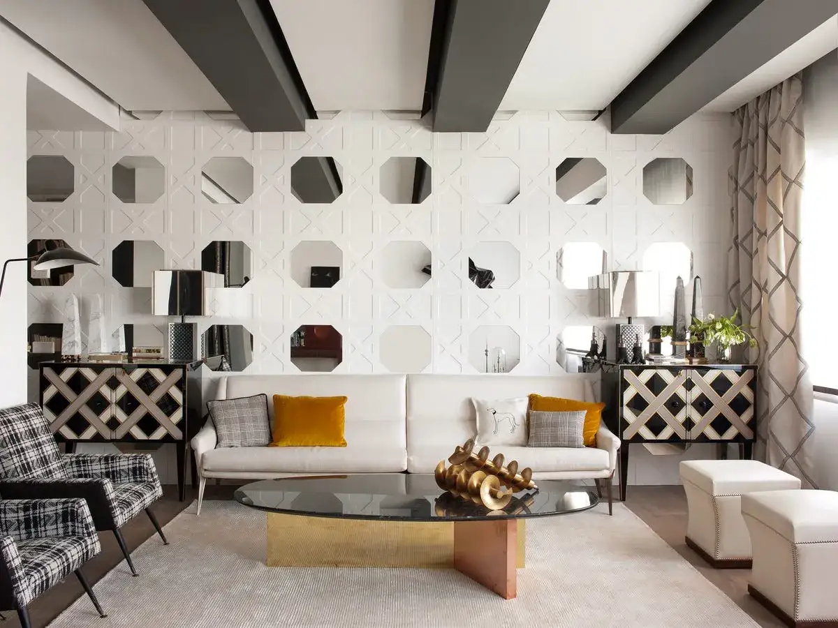 Sofá blanco y dos sillones a cuadros en un salón moderno. La pared tiene un diseño geométrico con espejos octogonales, como si quisieran colgar cuadros.