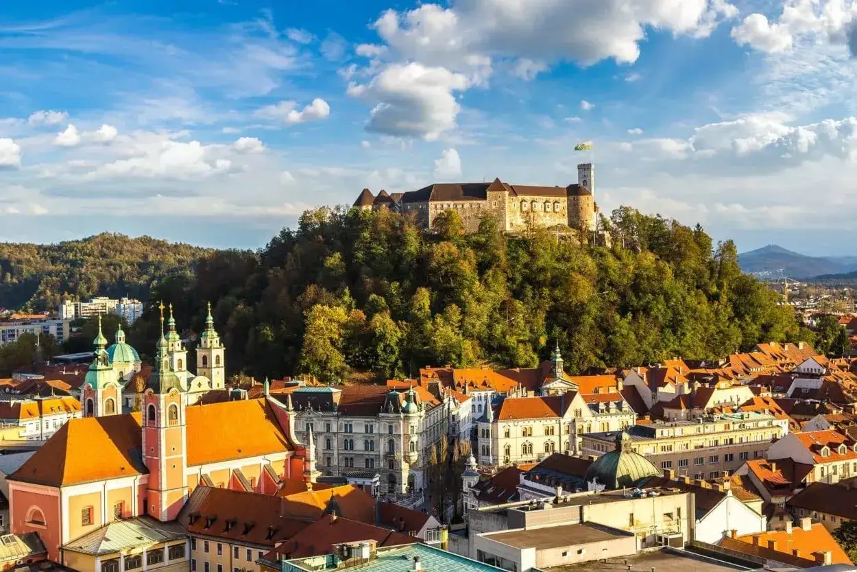 Vy över Ljubljana, Sloveniens huvudstad, med dess slott på kullen och kyrkor med gröna kupoler.