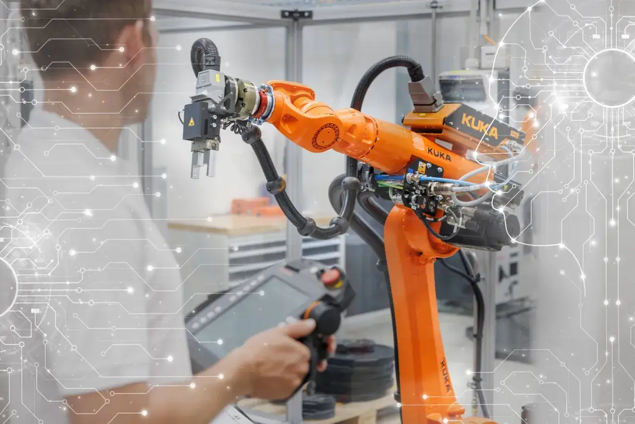 Un operario controla un brazo rob&oacute;tico KUKA, s&iacute;mbolo de la automatizaci&oacute;n en la manufactura moderna.