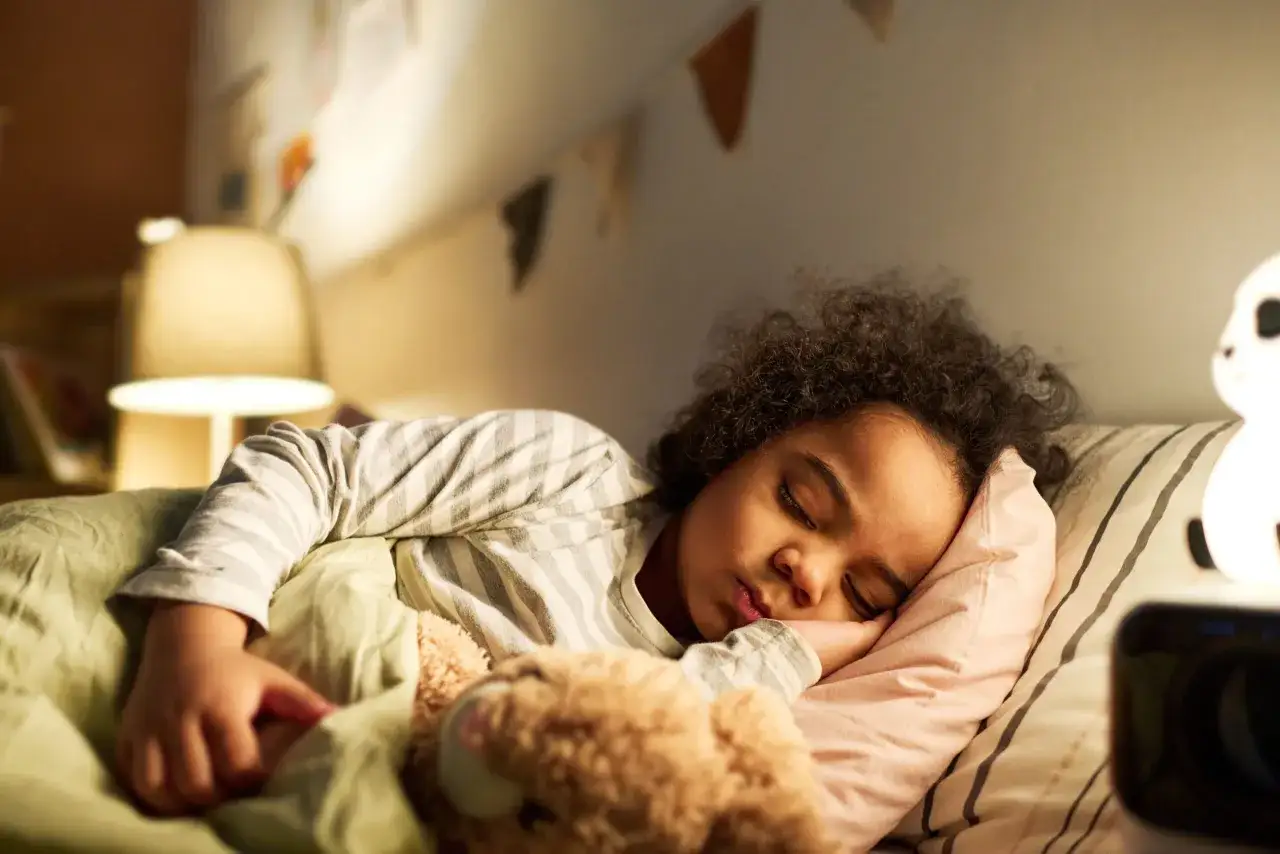 Ni&ntilde;a de 10 a&ntilde;os duerme abrazada a su oso, quiz&aacute;s superando problemas para dormir.