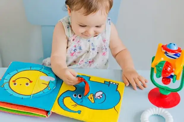 dziecko bawi się książeczką sensoryczną, różne typy książeczek sensorycznych