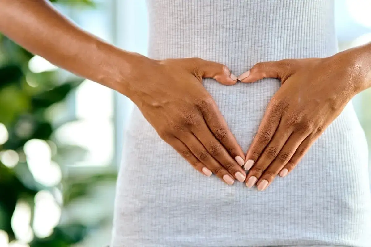 Manos formando un corazón sobre el abdomen. Cuidado con el vapear, da gases y puede afectar tu bienestar.