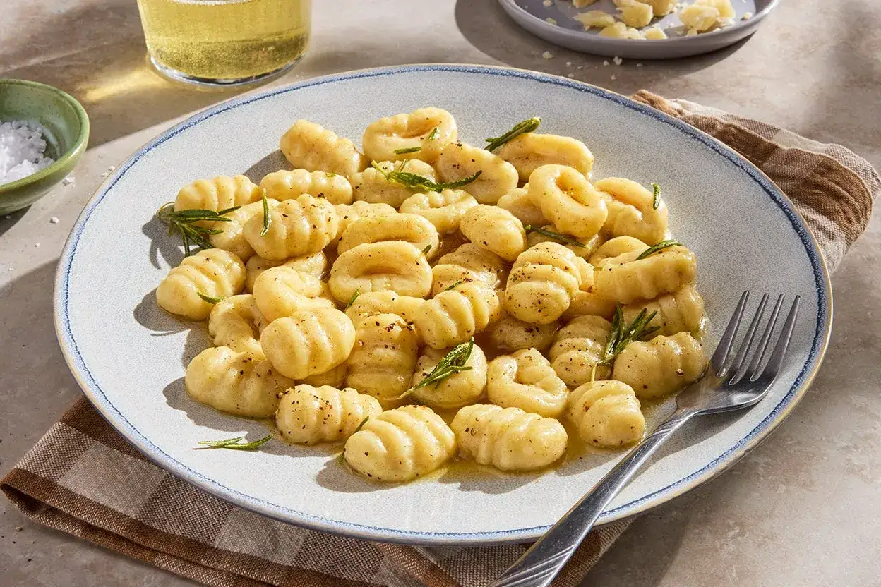 Pyszne gnocchi z delikatnym sosem maślanym i rozmarynem, posypane pieprzem. Idealne na lekki obiad.