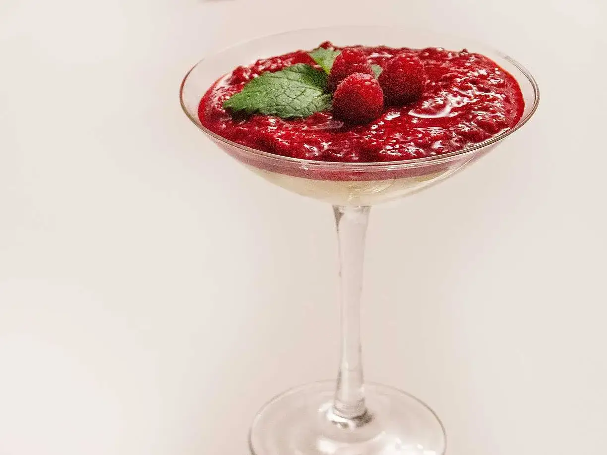 En läcker frozen cheesecake i ett glas, toppad med hallon och mynta. Perfekt för en sommardessert.
