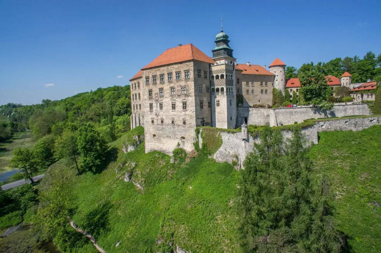 Zamek na skale, idealne z ciekawych miejsc do 100 km od Katowic. Otoczony zielenią, z wieżą i czerwonymi dachami.