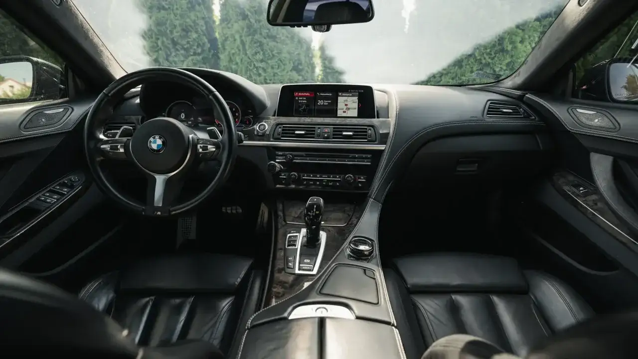 Wnętrze BMW 640i: skórzana tapicerka, kierownica, deska rozdzielcza z ekranem multimediów i nawigacją.