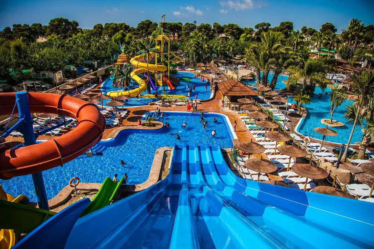 Parque acuático con toboganes, piscinas y palmeras. Ideal para hoteles temáticos para niños, donde la diversión está garantizada.