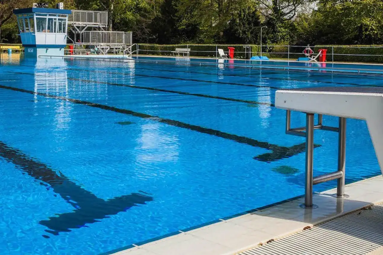 Das leere Freibad Rheda lädt mit seinem klaren blauen Wasser und den Sprungbrettern zum Schwimmen ein.