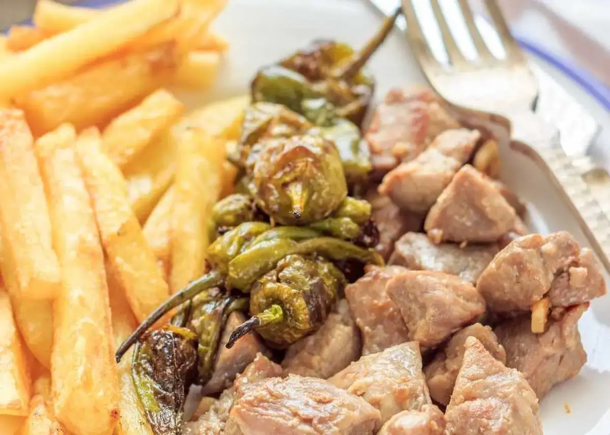 Raxo con patatas fritas y pimientos verdes asados. Un plato contundente y delicioso.