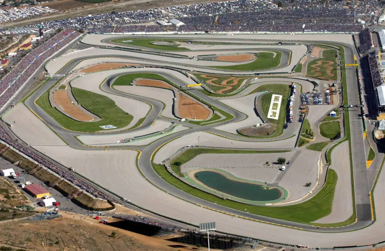 Vista a&eacute;rea de un circuito de carreras con gradas llenas de espectadores. Parece que hoy hay una carrera emocionante.