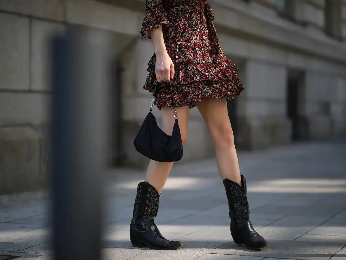 Moda estiva: come indossare i texani con un vestito floreale e borsa nera. Stile audace e chic.