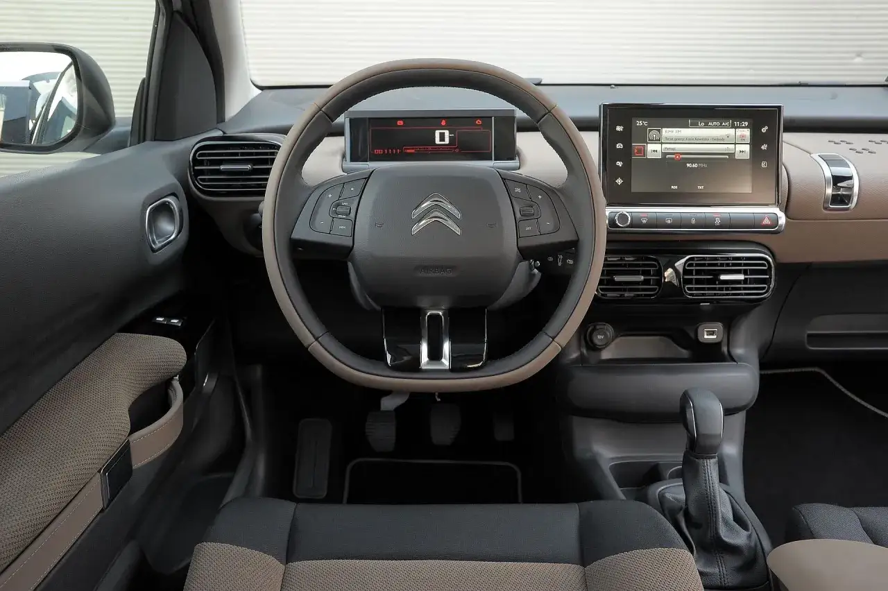 Wnętrze Citroen Cactus: kierownica, ekran multimediów, dźwignia zmiany biegów i cyfrowy wyświetlacz.