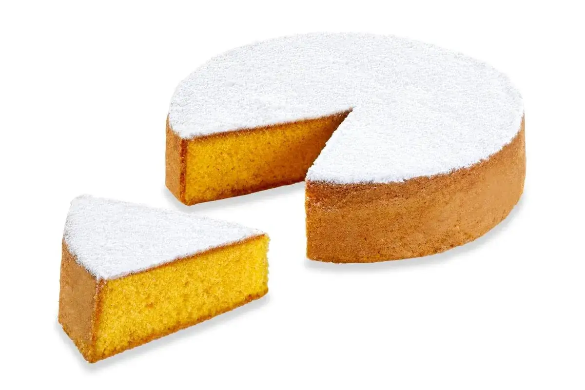 Una soffice torta paradiso, cosparsa di zucchero a velo, con una fetta tagliata.