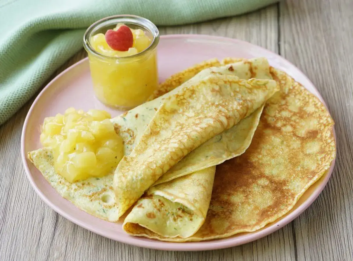 Zucchini-Pfannkuchen mit Apfelmus und einem roten Herz-Garnitur.
