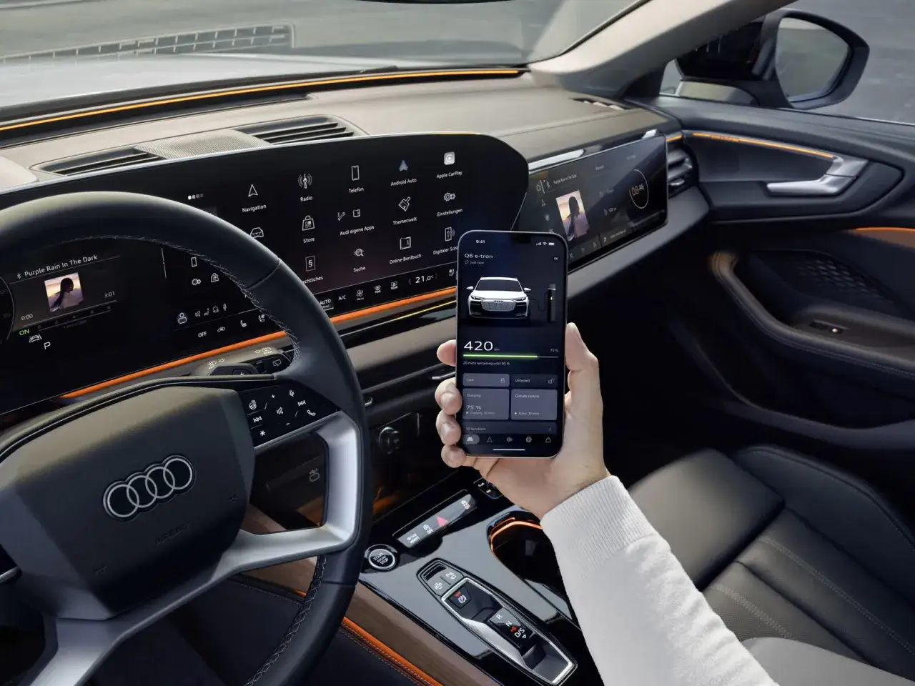 Il **sistema infotainment** dell'Audi Q6 e-tron mostra la musica e le informazioni di ricarica su smartphone.
