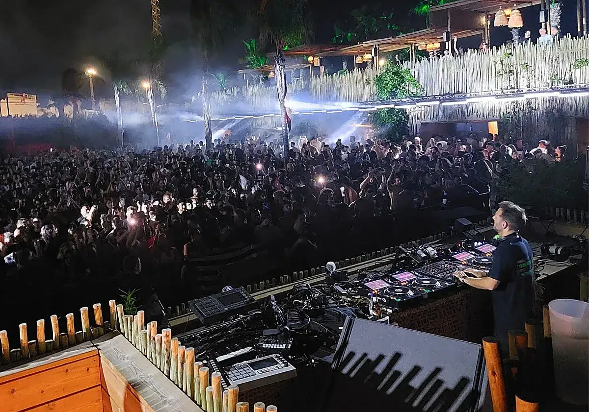 DJ Charlotte de Witte en Málaga, una multitud baila bajo luces y humo.