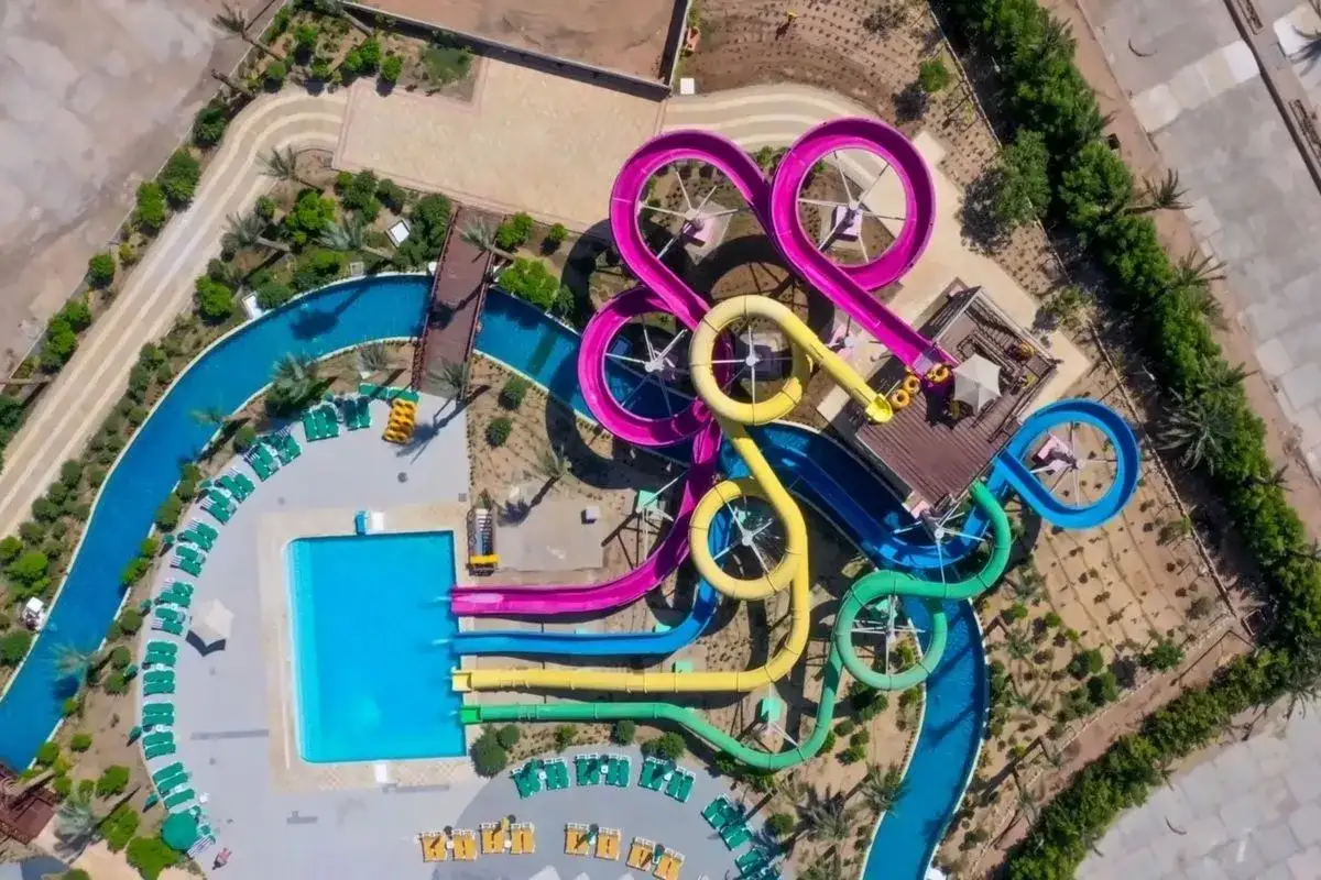 Widok z lotu ptaka na kolorowe zjeżdżalnie wodne i baseny. Wiele osób szuka opinii o Blend Club Aqua Resort, a ten widok pokazuje jego atrakcje.