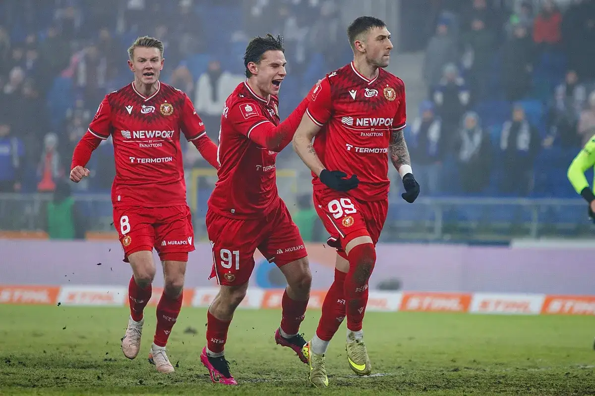 Piłkarze w czerwonych strojach, z numerami 8, 91 i 99, biegną po boisku. Emocje po meczu Widzew Łódź – Cracovia.