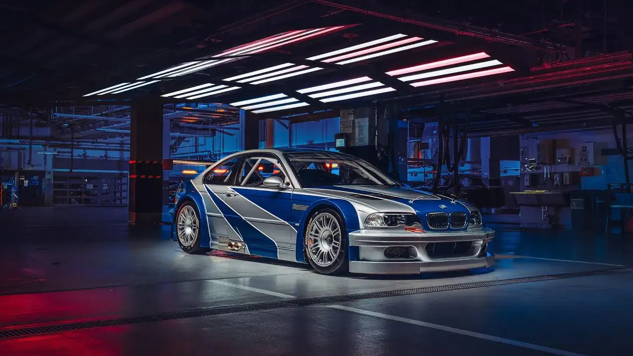 Wyścigowe e46 BMW M3 GTR w garażu, z niebiesko-srebrnym malowaniem, gotowe do akcji.