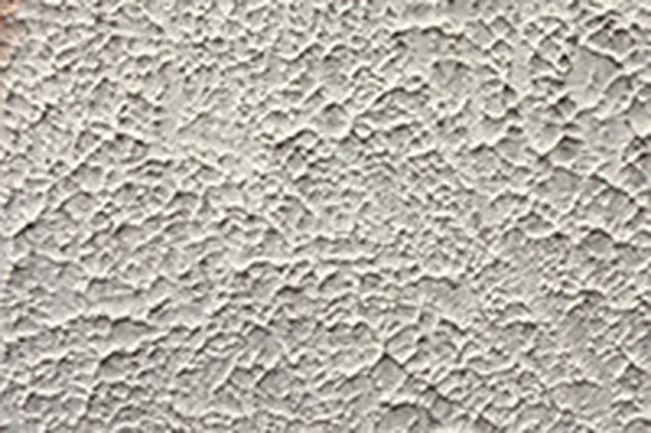 Un mur avec un motif crépi intérieur moderne, offrant une texture riche et un aspect contemporain.