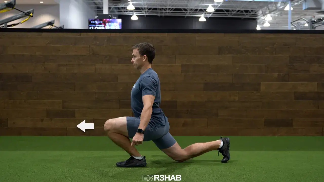 Man utf&ouml;r split squats p&aring; ett gym. En vit pil pekar &aring;t v&auml;nster.