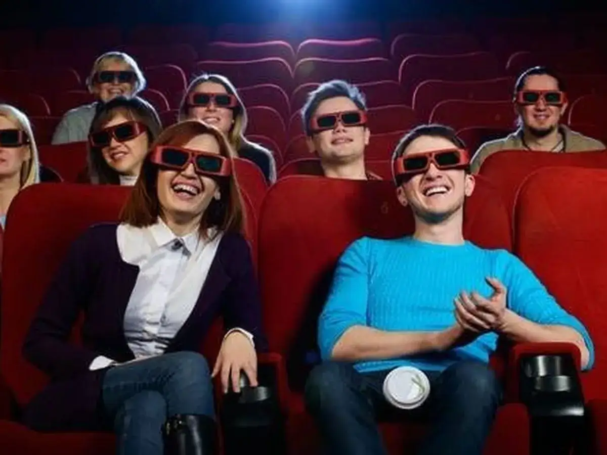 Ludzie w okularach 3D śmieją się w kinie. Czekają na sequel, który pewnie będzie równie zabawny!