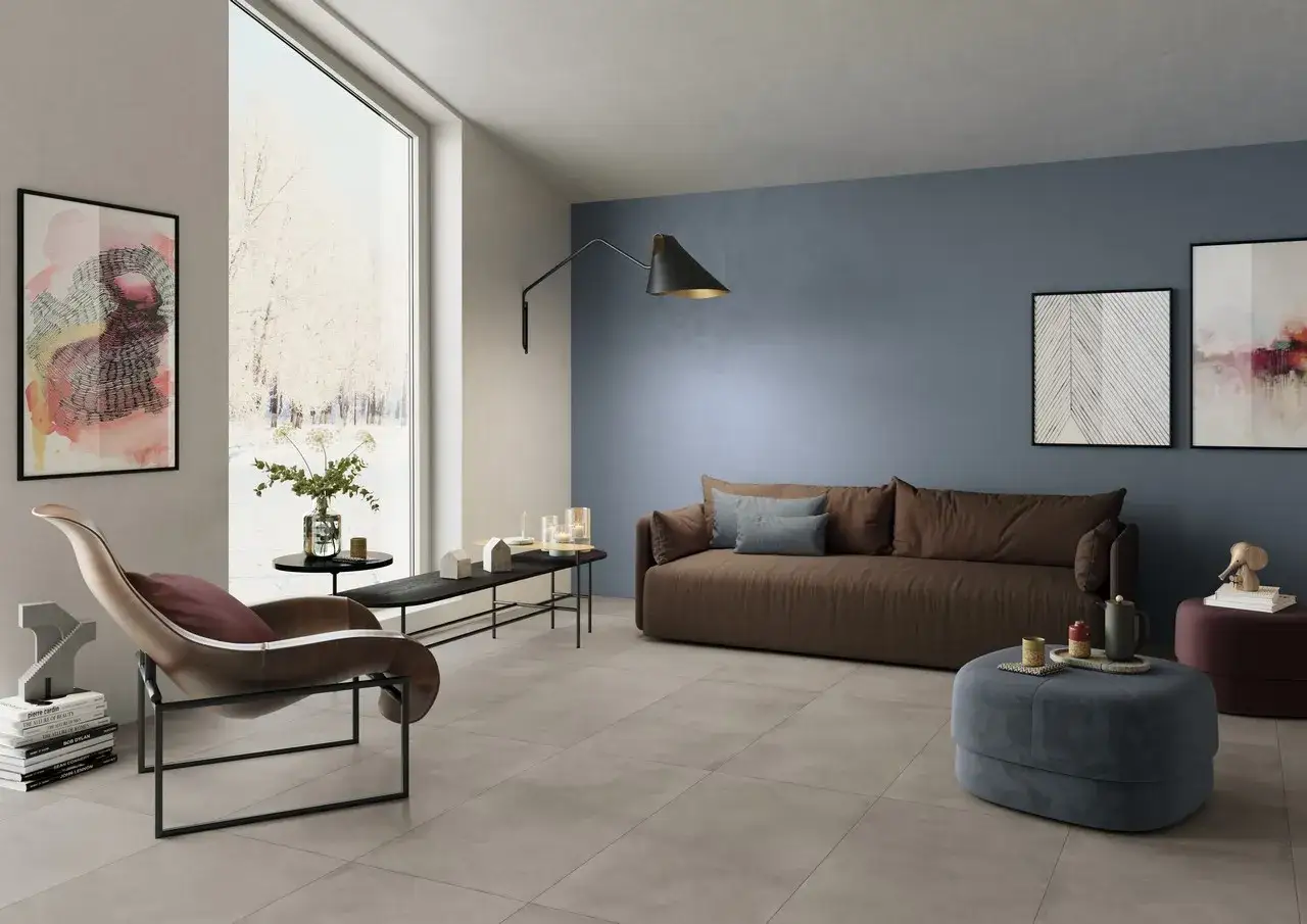 Soggiorno moderno con **pavimento grigio** e **pareti tortora** che creano un'atmosfera rilassante. Divano marrone, poltrona di design e opere d'arte.