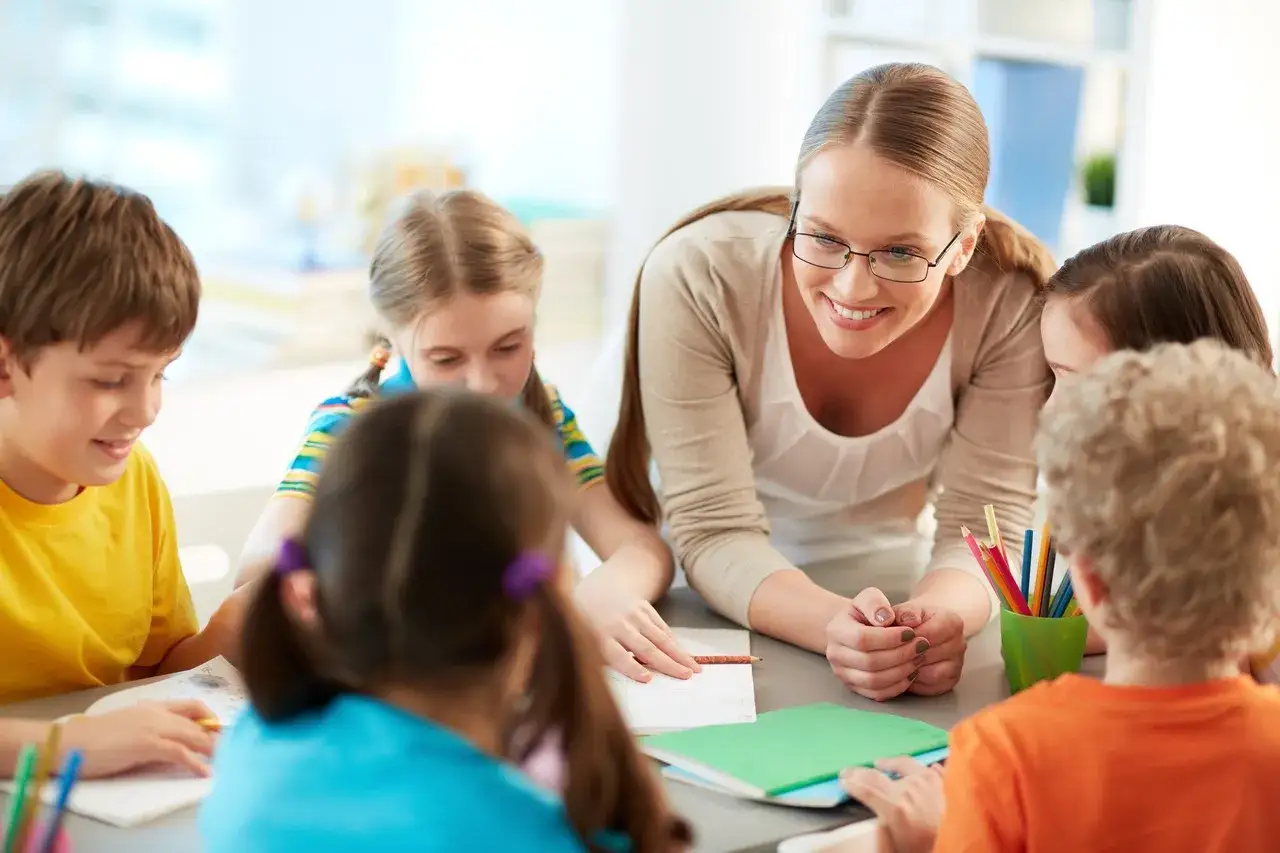 Nauczycielka klas 1-3 z uśmiechem wspiera dzieci w nauce. Ile zarabia taki pedagog? To pytanie nurtuje wielu.