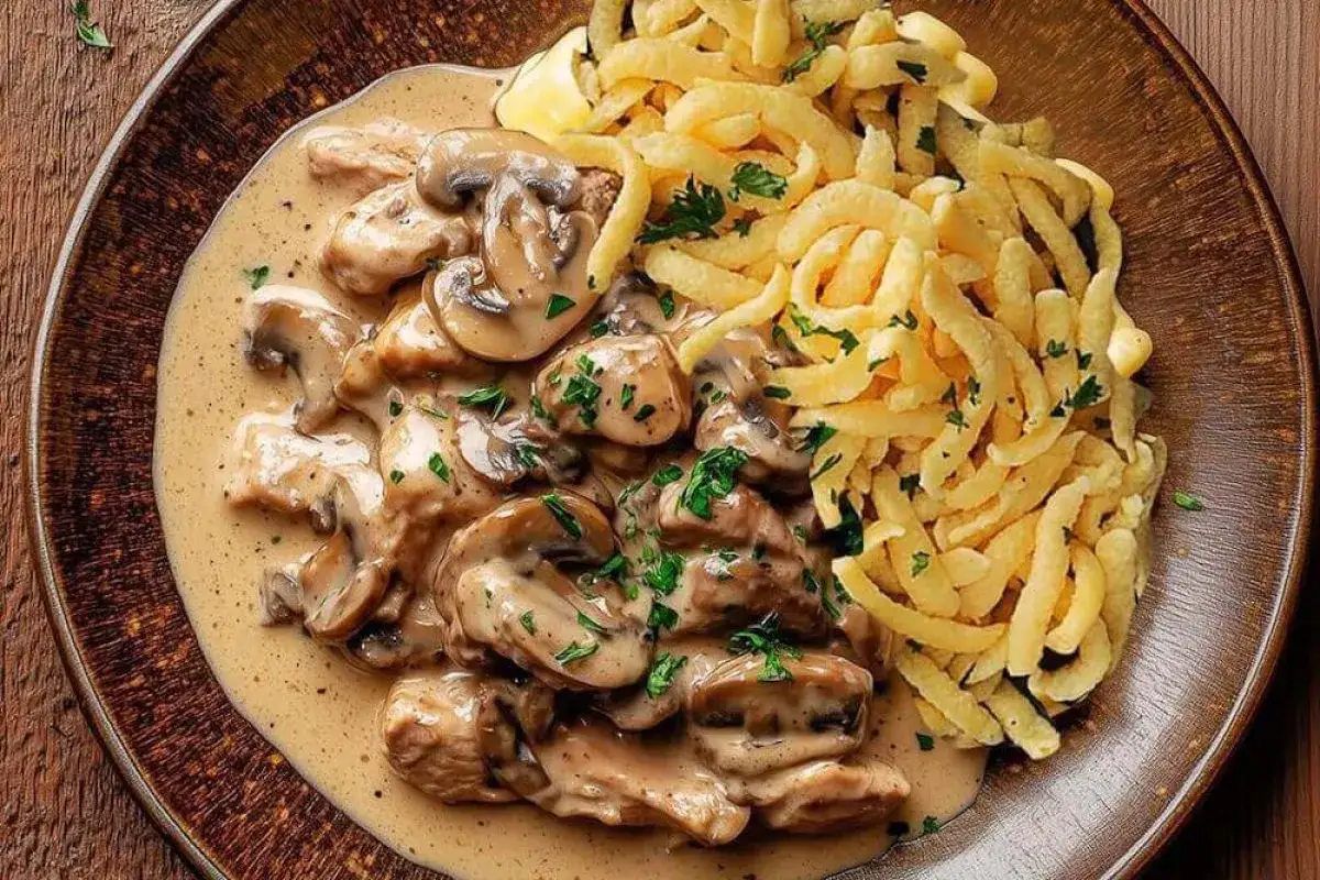 Ein köstliches geschnetzeltes Rezept mit zarten Fleischstreifen, cremiger Pilzsoße und knusprigen Spätzle, garniert mit Petersilie.