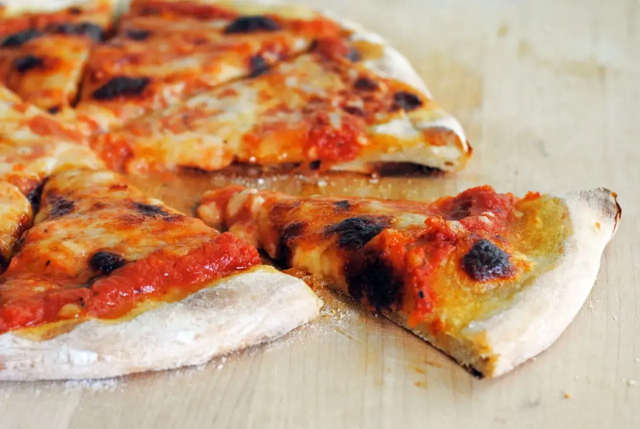 En skivad pizza med ost och tomats&aring;s, perfekt f&ouml;r ett nytt recept p&aring; New York pizza.