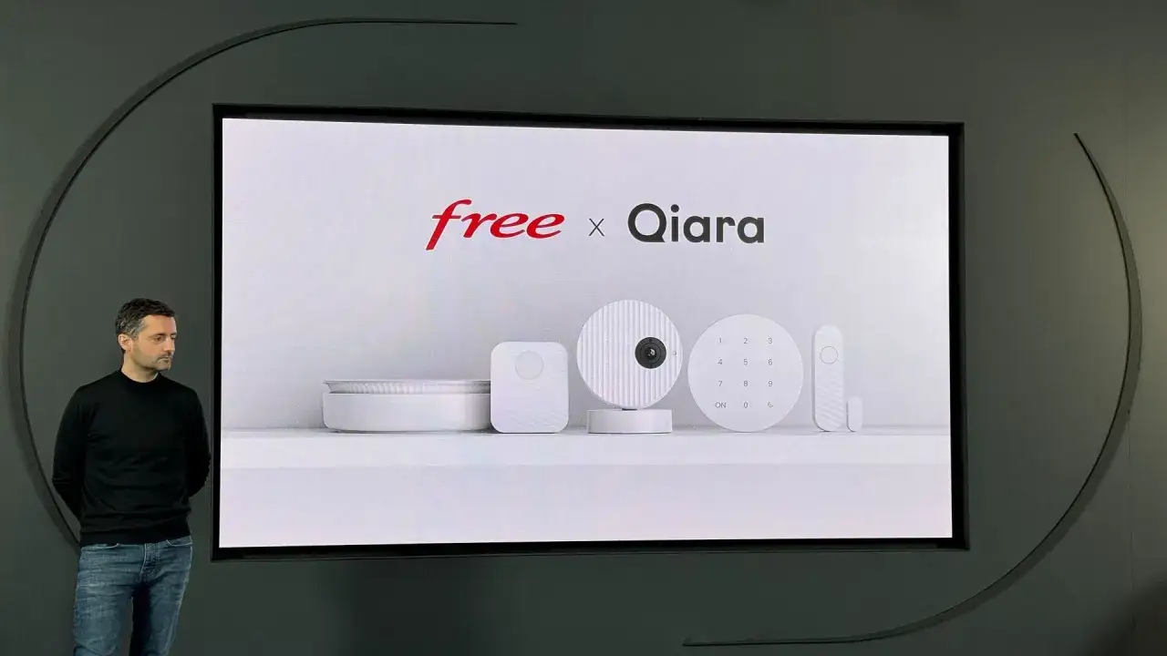 Présentation du système de sécurité Qiara, une caméra compatible Freebox Delta, avec un homme en noir regardant l'écran.