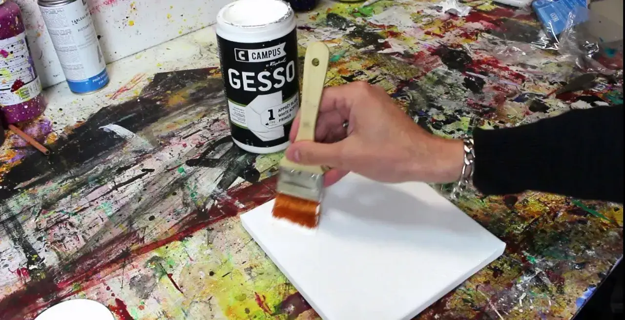 Application d'une couche de gesso sur une toile. Le pot de gesso indique 