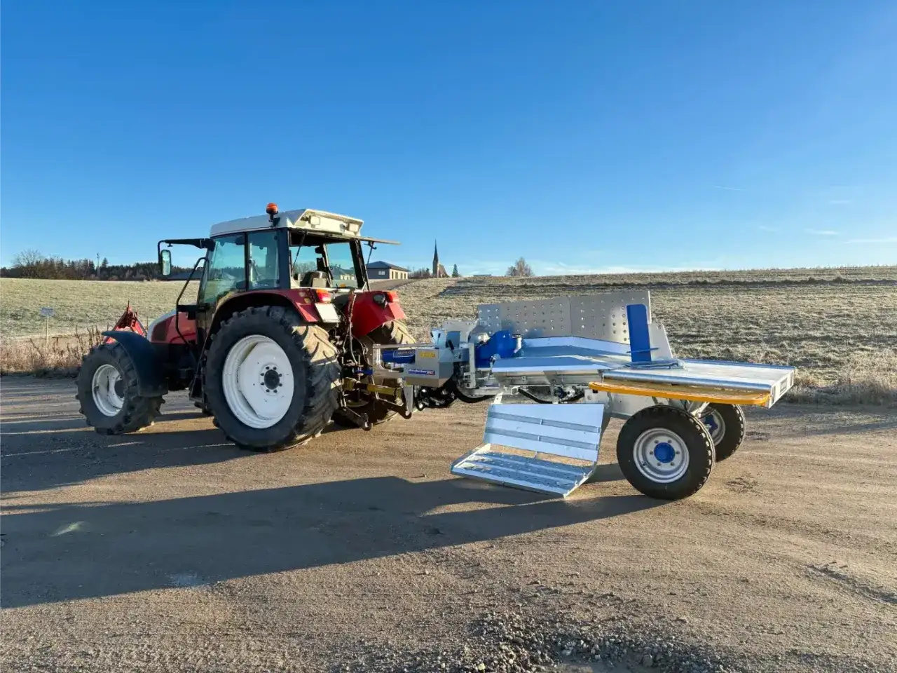 Traktor mit Binderberger WS 700 Zapfwelle, bereit f&uuml;r den Holzeinsatz im Freien.