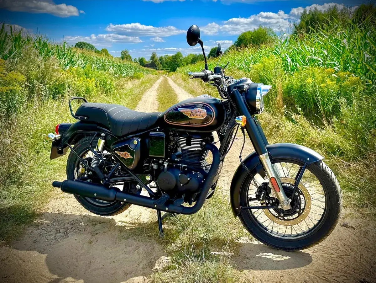 Czarny Royal Enfield Classic 350 na polnej drodze. Idealny na wyprawę, gdy znasz jego dane techniczne.