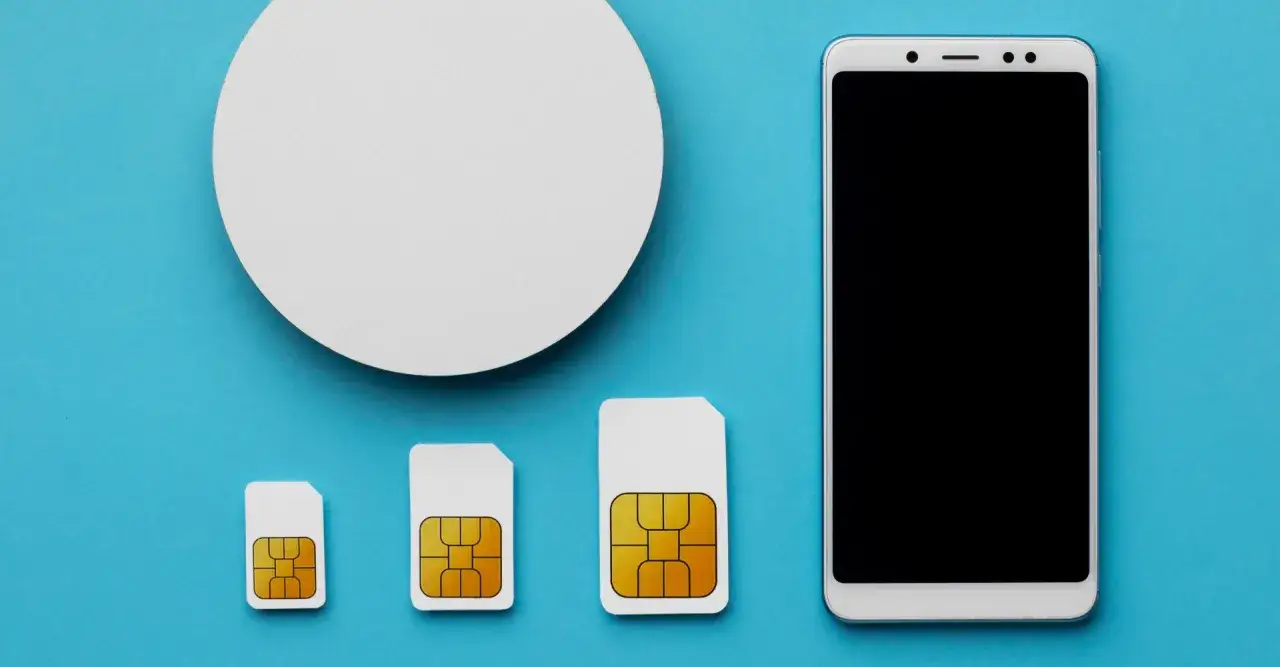 Tre SIM-kort i olika storlekar, fr&aring;n minsta nano sim kort till st&ouml;rsta, bredvid en smartphone.