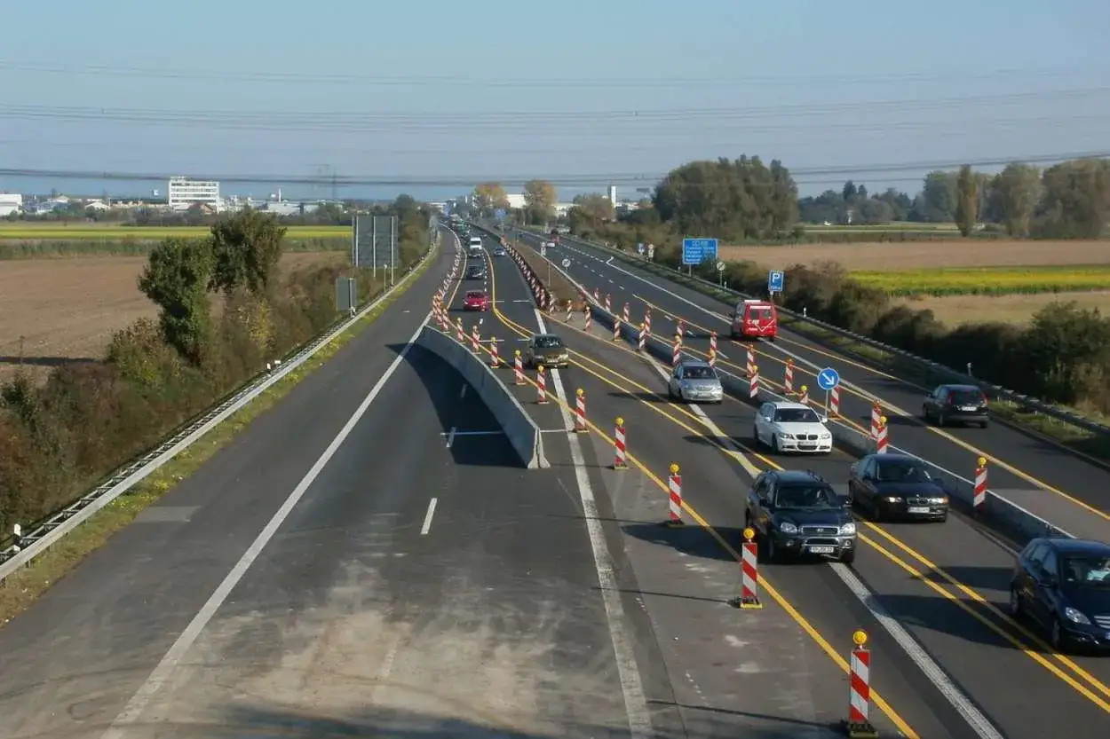 Baustelle auf der ADAC A2: Autos fahren durch eine Baustelle mit Leitbaken und Betonbarrieren.