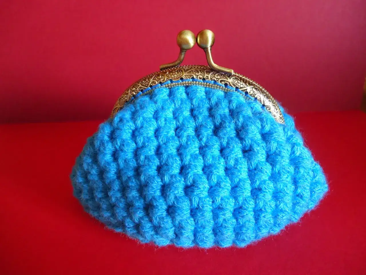 Monedero crochet azul vibrante con cierre met&aacute;lica dorada. Perfecto para guardar tus tesoros.