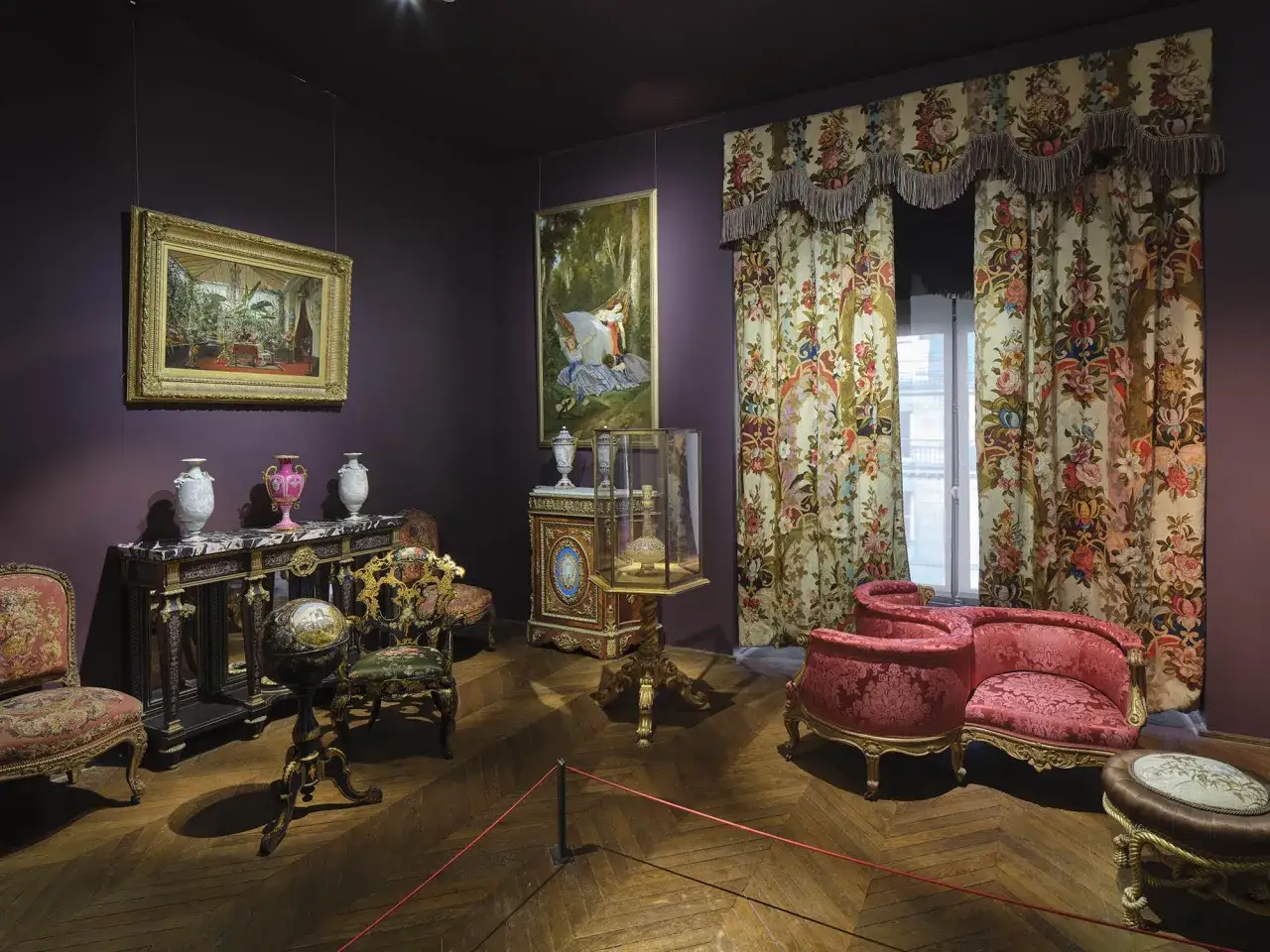 Salon d'apparat, mobilier et tableaux évoquant la période Empire. Fauteuils, console, globe terrestre, vitrine et tentures florales.