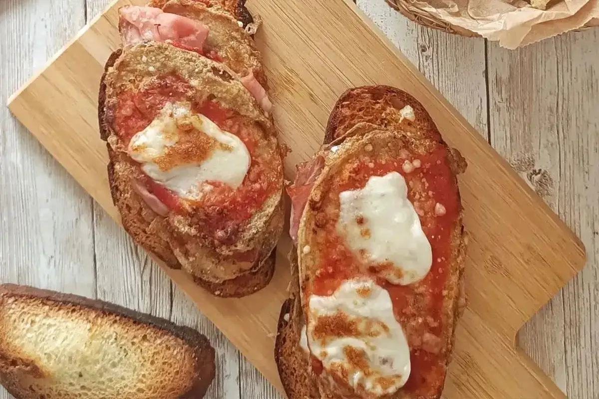 Deliziosi crostini con melanzane, pomodoro e mozzarella filante, pronti per essere gustati.