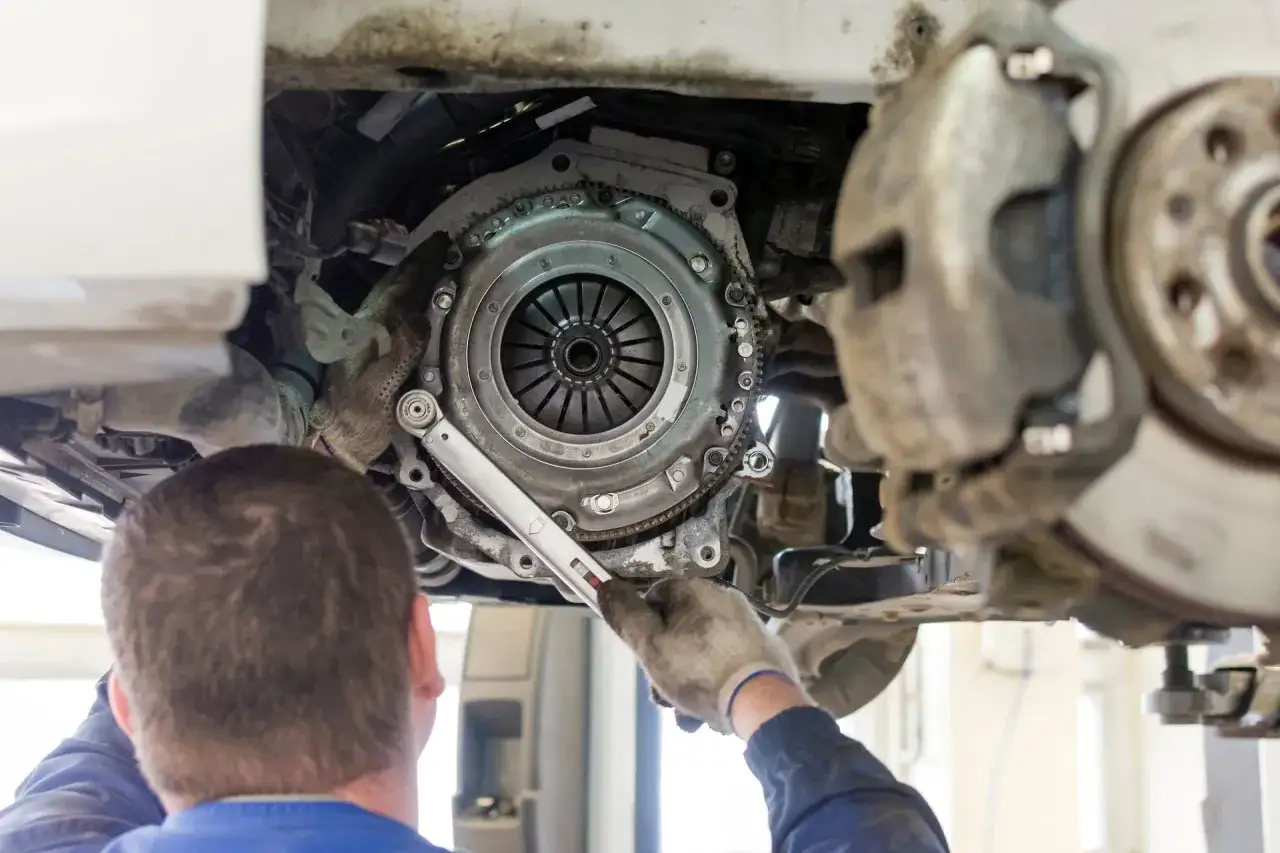Mechanik dokręca śruby koła zamachowego. Może to pomóc, gdy sprzęgło skrzypi przy puszczaniu.