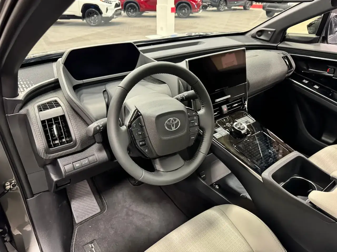 Wnętrze Toyoty bz4x. Nowoczesna deska rozdzielcza, kierownica i ekran multimedialny. Sprawdź atrakcyjną toyota bz4x cenę.
