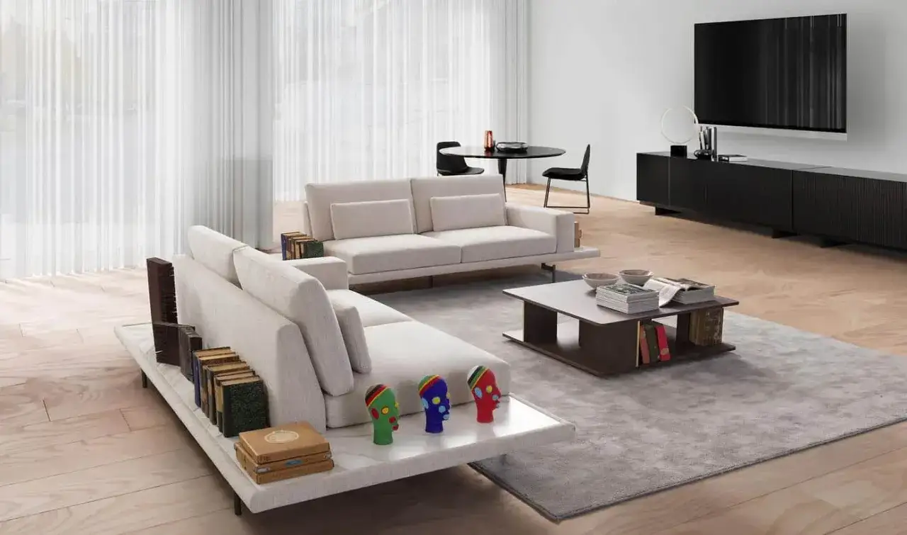Un salon moderne avec deux canapés différents, une table basse, une TV et des objets décoratifs colorés.