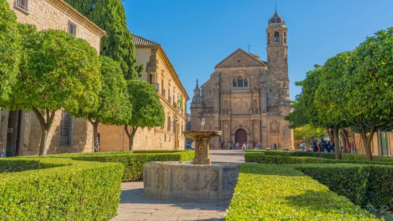 Plaza con fuente y edificios históricos. Un lugar perfecto que ver en Úbeda y Baeza, con árboles y jardines cuidados.