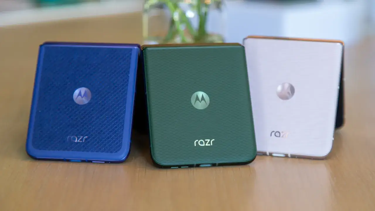 Trzy składane telefony Motorola RAZR w kolorach: niebieskim, zielonym i r&oacute;żowym. Motorola, znana z innowacji, ma swoje korzenie w USA.