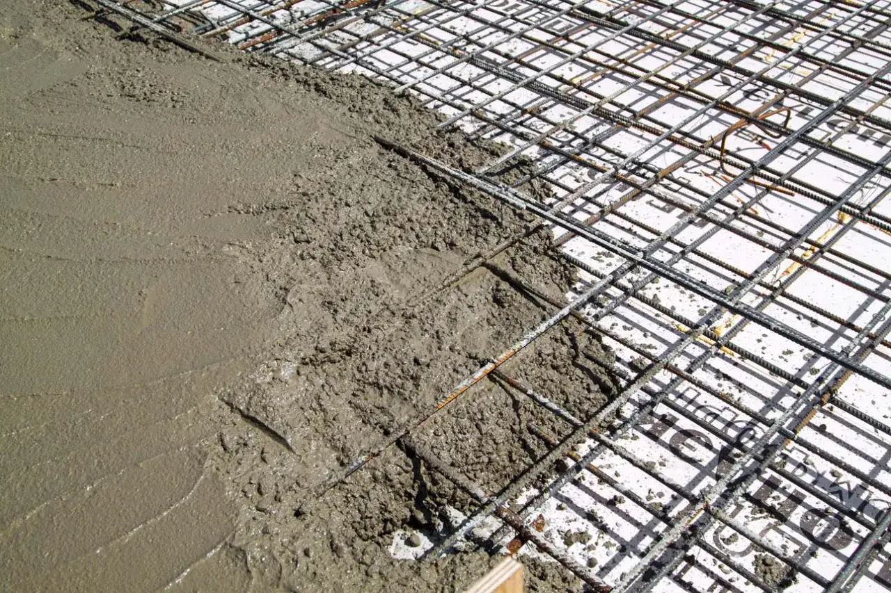 Coulée de béton frais sur une armature métallique. Idéal pour estimer le prix dalle béton m2.
